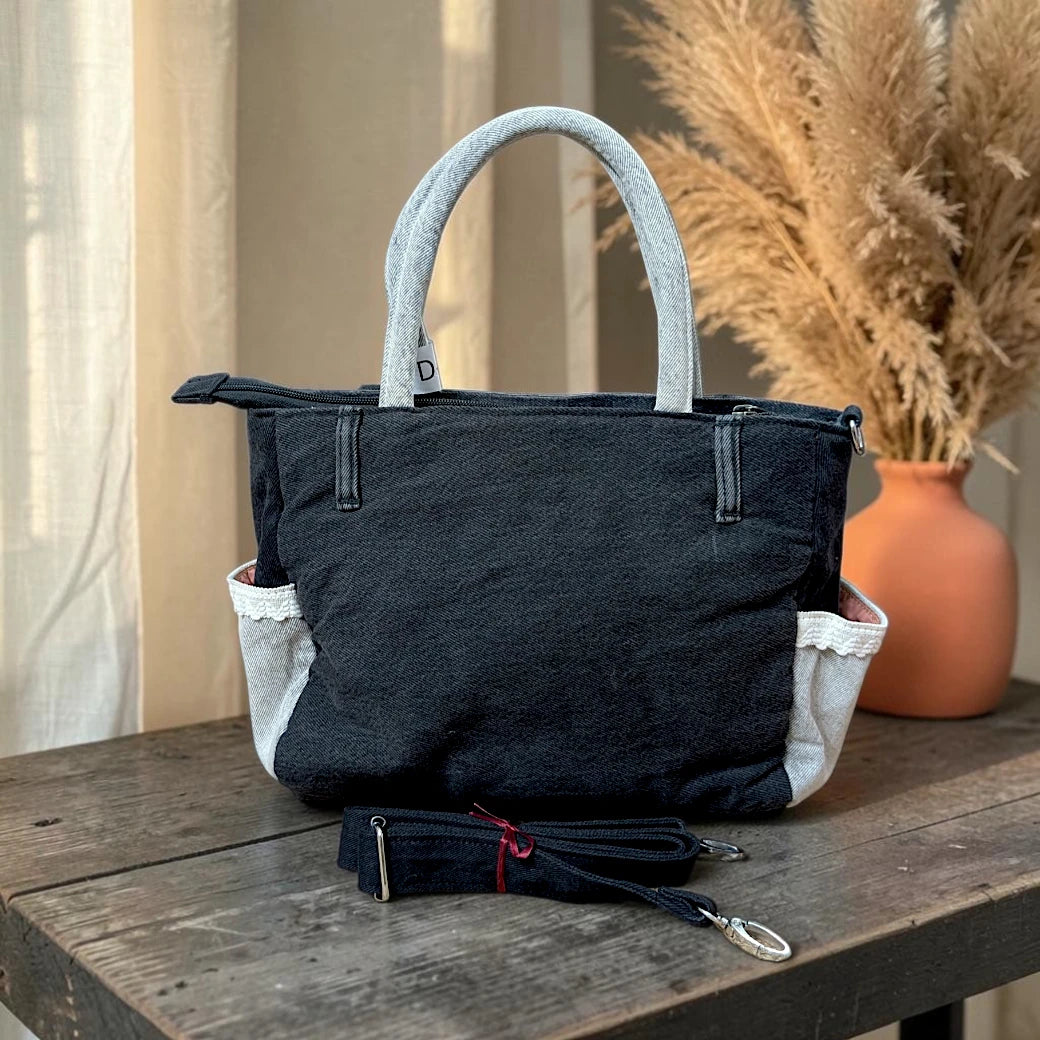 Bidora black denim tote handbag with light-wash handles, exterior pockets, and a detachable shoulder strap.