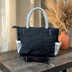 Bidora black denim tote handbag with light-wash handles, exterior pockets, and a detachable shoulder strap.