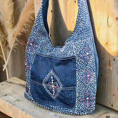 Bidora indigo denim hobo shoulder bag with intricate white and pink hand-stitched embroidery and front pocket