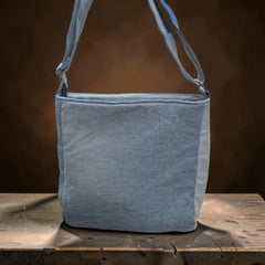 Bidora patchwork denim crossbody bag with adjustable shoulder strap, featuring light blue repurposed fabric textures.