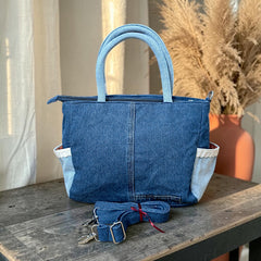 Bidora two-tone denim handbag with lace-trimmed side pockets, top handles, and a detachable shoulder strap.