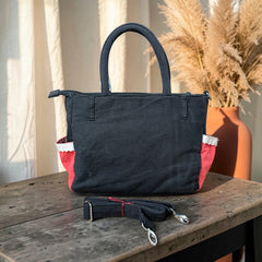 Bidora black denim tote handbag with red side panels, white lace trim, and a detachable adjustable shoulder strap.