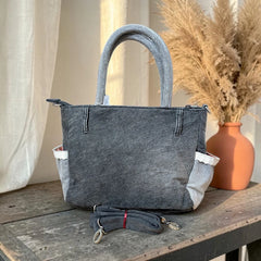 Bidora charcoal grey denim handbag with side pockets, lace trim, top handles, and a detachable shoulder strap.