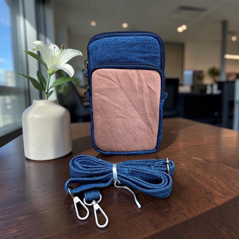 Bidora two-tone denim crossbody phone pouch with a detachable blue strap, featuring zippered compartments.
