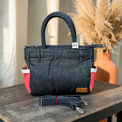 Bidora dark wash denim handbag with red side pockets, white lace trim, top handles, and detachable shoulder strap.