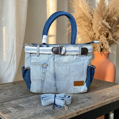 Bidora two-tone blue denim handbag with belt trim, side pockets, sturdy handles, and detachable shoulder strap.