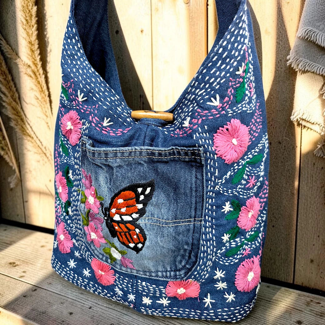 Bidora denim hobo shoulder bag with pink floral embroidery and a butterfly motif on the front pocket