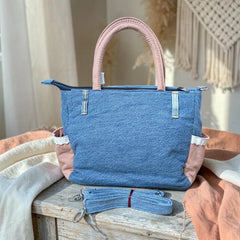 Bidora denim handbag with dusty-pink side panels, lace trim, top handles, and a detachable shoulder strap.