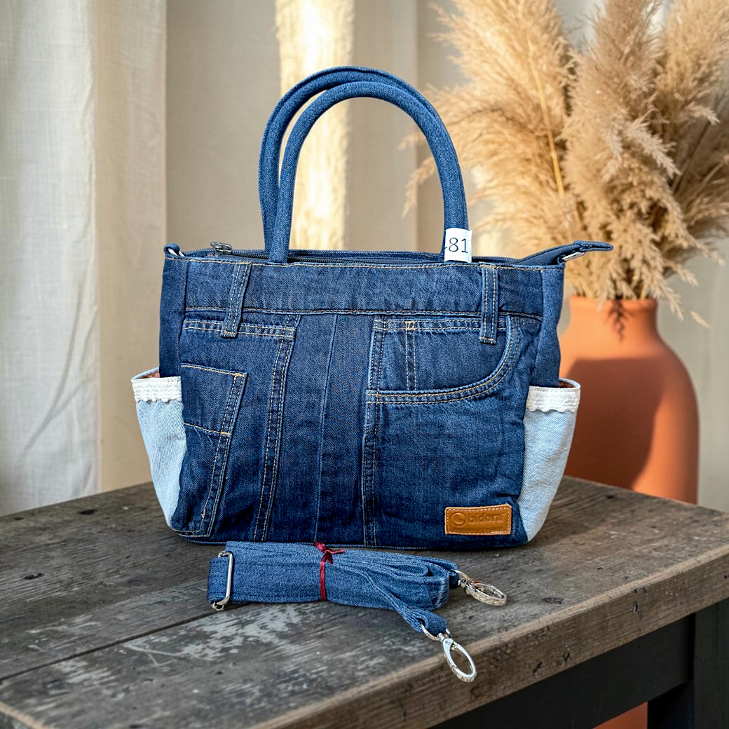 Bidora denim handbag with patchwork design, side pockets with lace trim, top handles, and detachable shoulder strap.