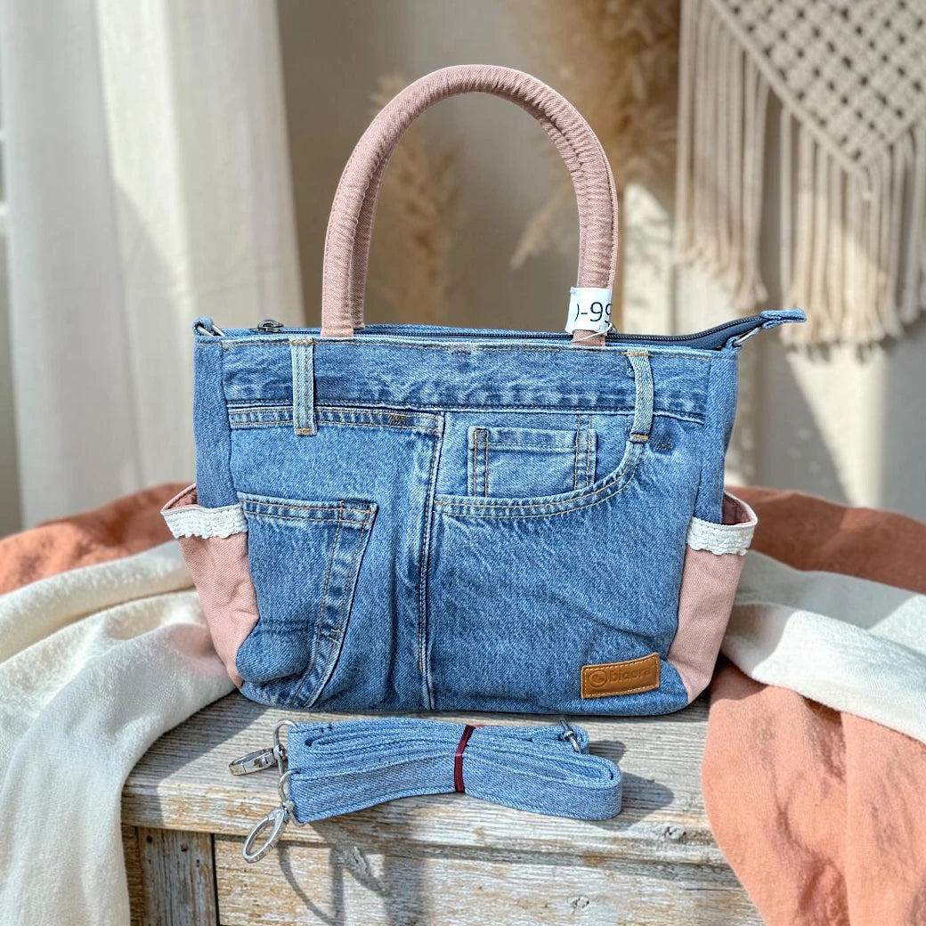 Bidora denim handbag with patchwork blue fabric, dusty-pink side panels, lace trim, and detachable shoulder strap.