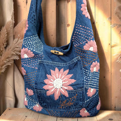 Bidora denim hobo shoulder bag featuring pink and white floral embroidery, stitching patterns, and a wooden toggle.