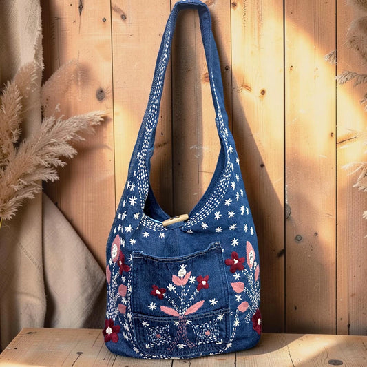 Bidora blue denim hobo shoulder bag with floral embroidery, front pocket, and wooden toggle closure