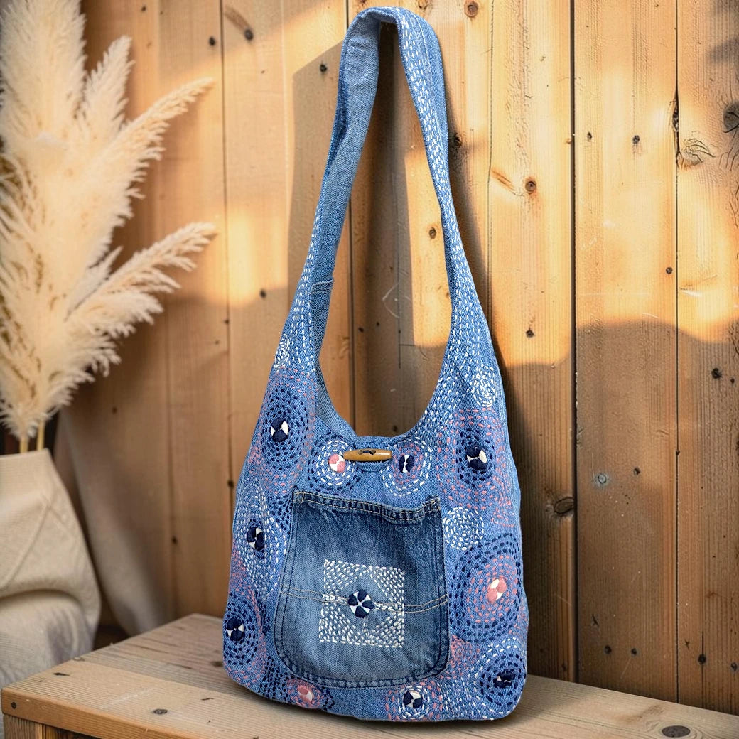 Bidora denim hobo shoulder bag with hand-stitched circular embroidery, patchwork detail, and wooden toggle closure.