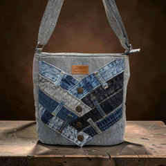 Bidora patchwork denim crossbody bag featuring geometric blue and charcoal reclaimed fabric with metal button accents.