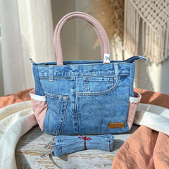 Bidora upcycled denim handbag with pink fabric accents, lace trim, top handles, and a detachable shoulder strap.