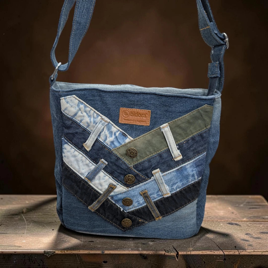 Bidora upcycled denim crossbody bag with chevron patchwork, metal buttons, and adjustable shoulder strap.