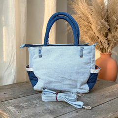 Bidora upcycled denim handbag with patchwork light and dark wash textures, lace-trimmed side pockets, and shoulder strap