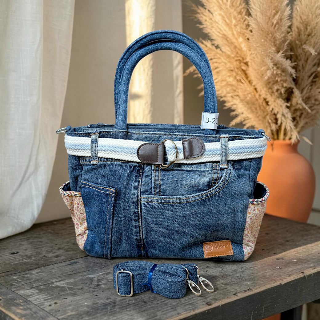 Bidora upcycled blue denim tote handbag with floral side pockets, white braided belt detail, and detachable strap.